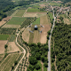 Drone flying above patchwork farmland near a village